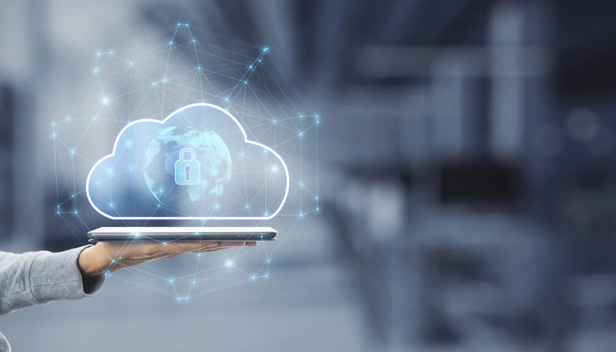 Eine Hand hält ein Tablet, darüber eingeblendet ein Wolkensymbol mit Vorhängeschloss und Netzlinien